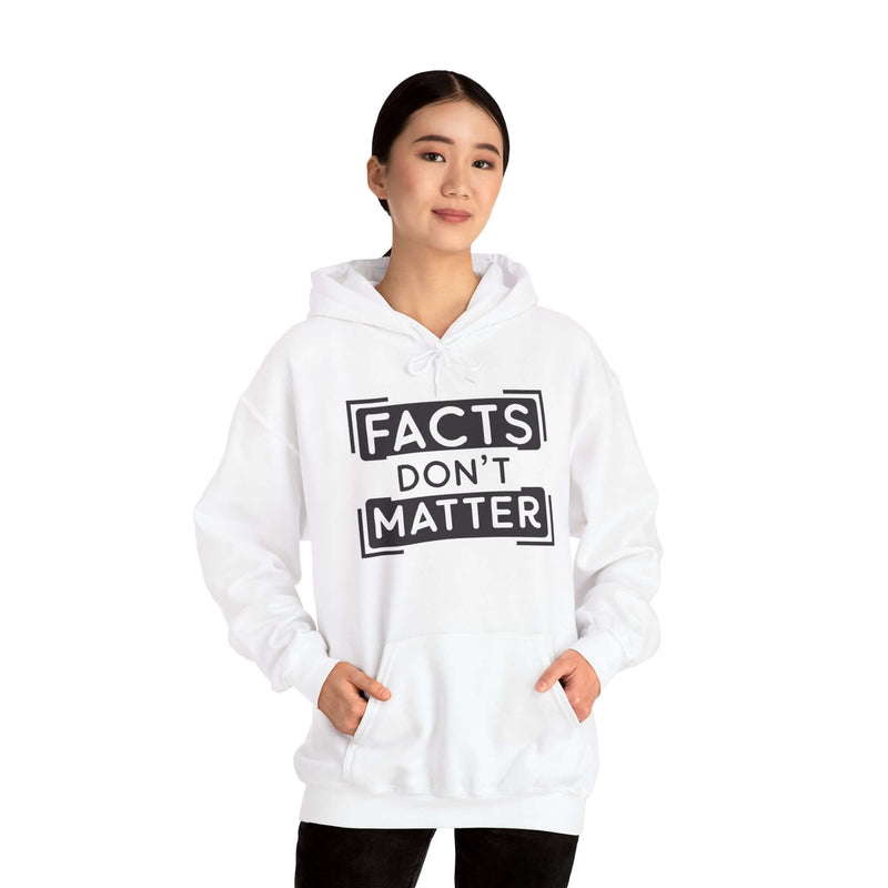 Woman wearing 'Facts Don't Matter' graphic hoodie in white, featuring a spacious kangaroo pocket and adjustable hood.